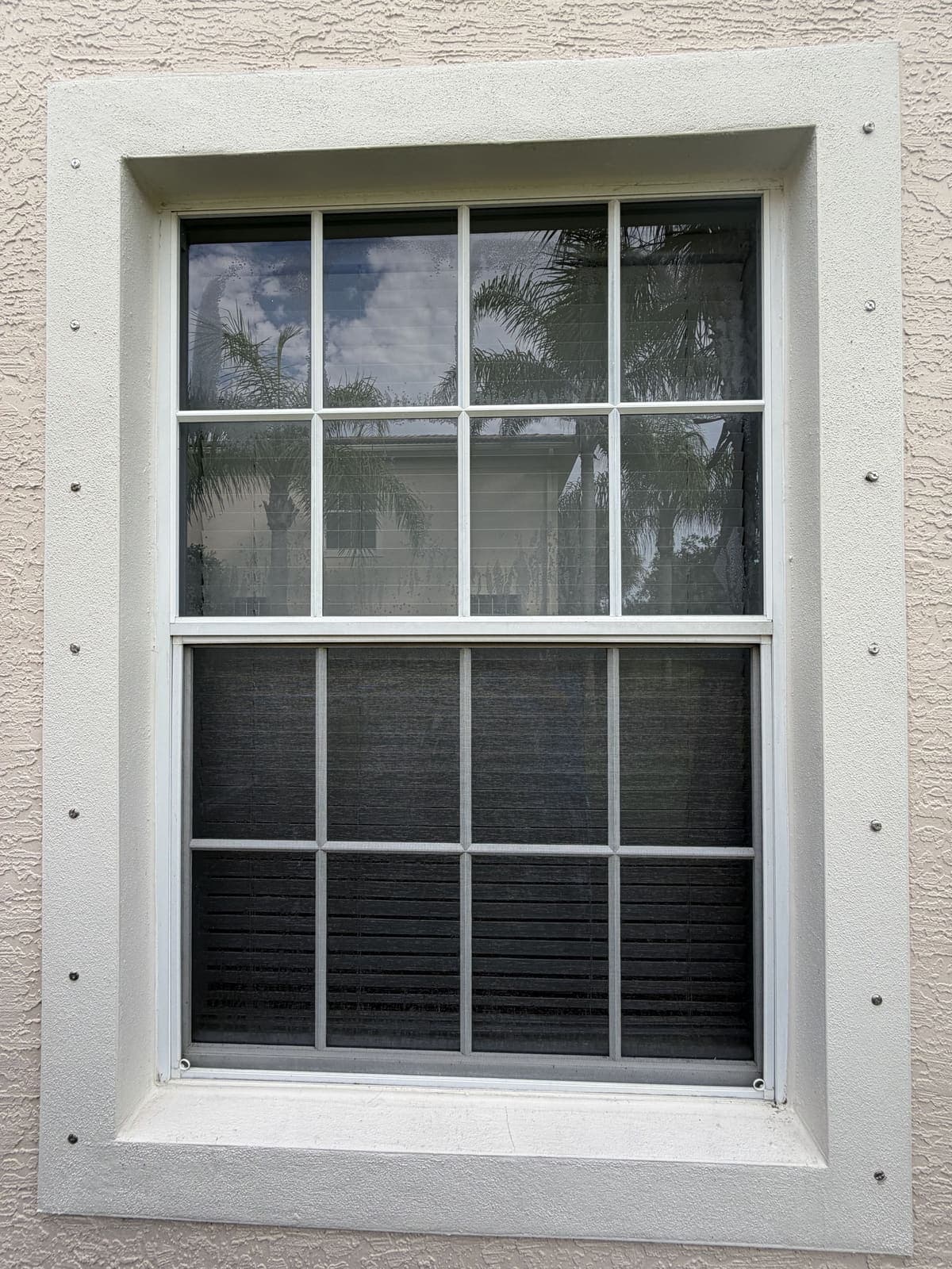 The same window after exterior cleaning, with clear glass and a bright white frame