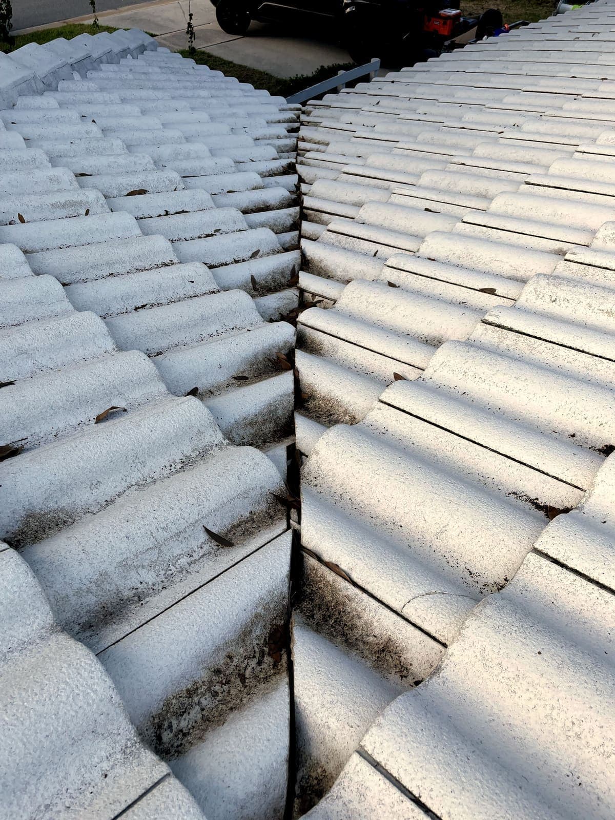 White tile roof with black algae streaks before cleaning
